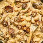 A creamy bowl of Mushroom Stroganoff Gnocchi garnished with sautéed mushrooms, freshly cracked black pepper, and parsley, showcasing tender gnocchi coated in a rich sauce.