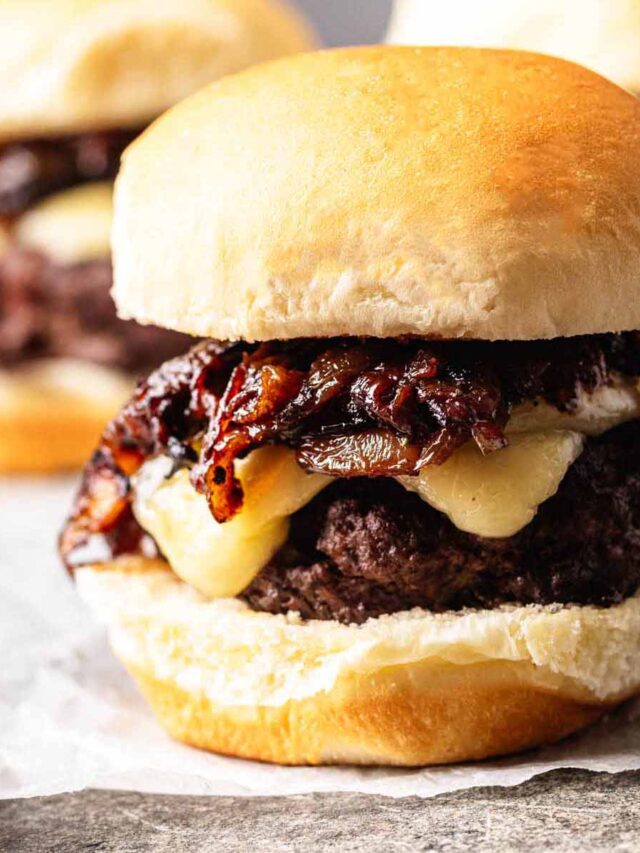 Close-up of a French onion slider with melted cheese and caramelized onions on a soft bun.
