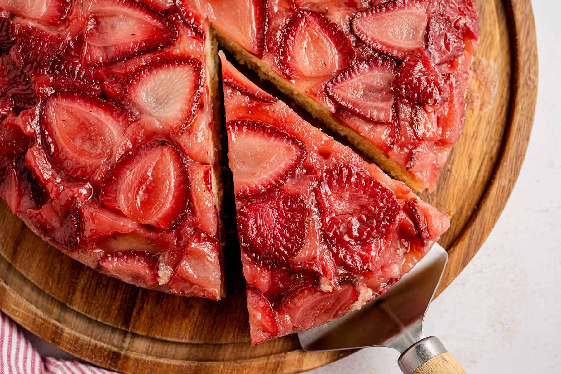 Overhead view of a strawberry upside down cake with a glossy layer of caramelized fresh strawberries