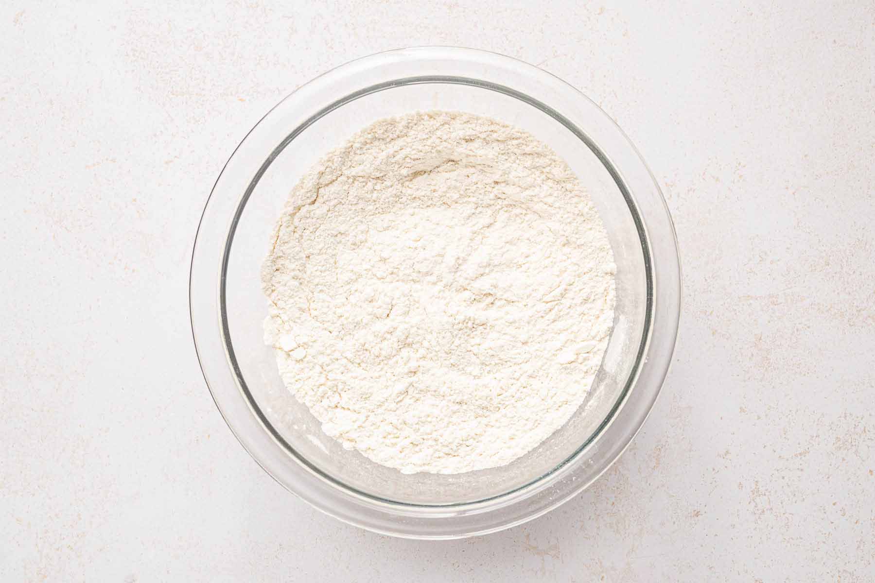 Flour, baking powder, and salt mixed together in a glass bowl for the cake batter