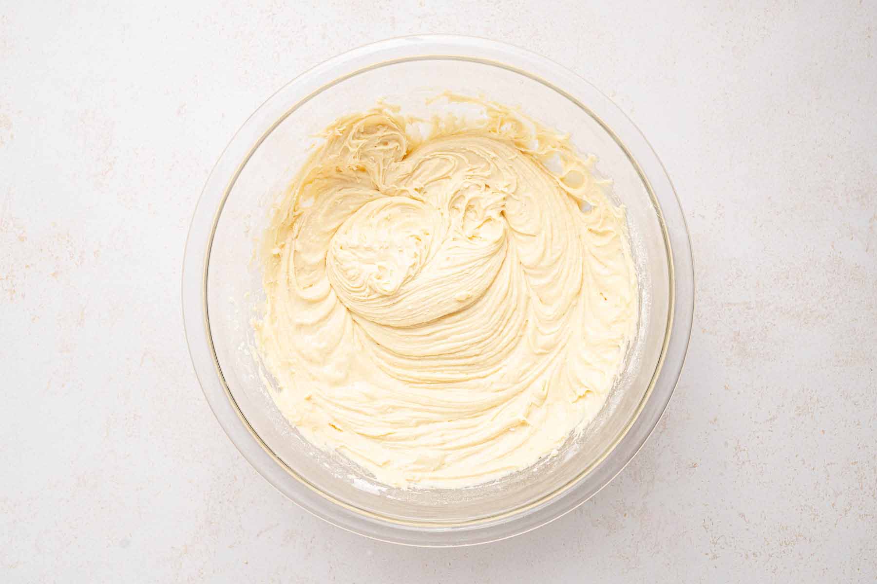 Strawberry upside down cake batter fully mixed in a glass bowl, ready to be spread over the strawberry layer