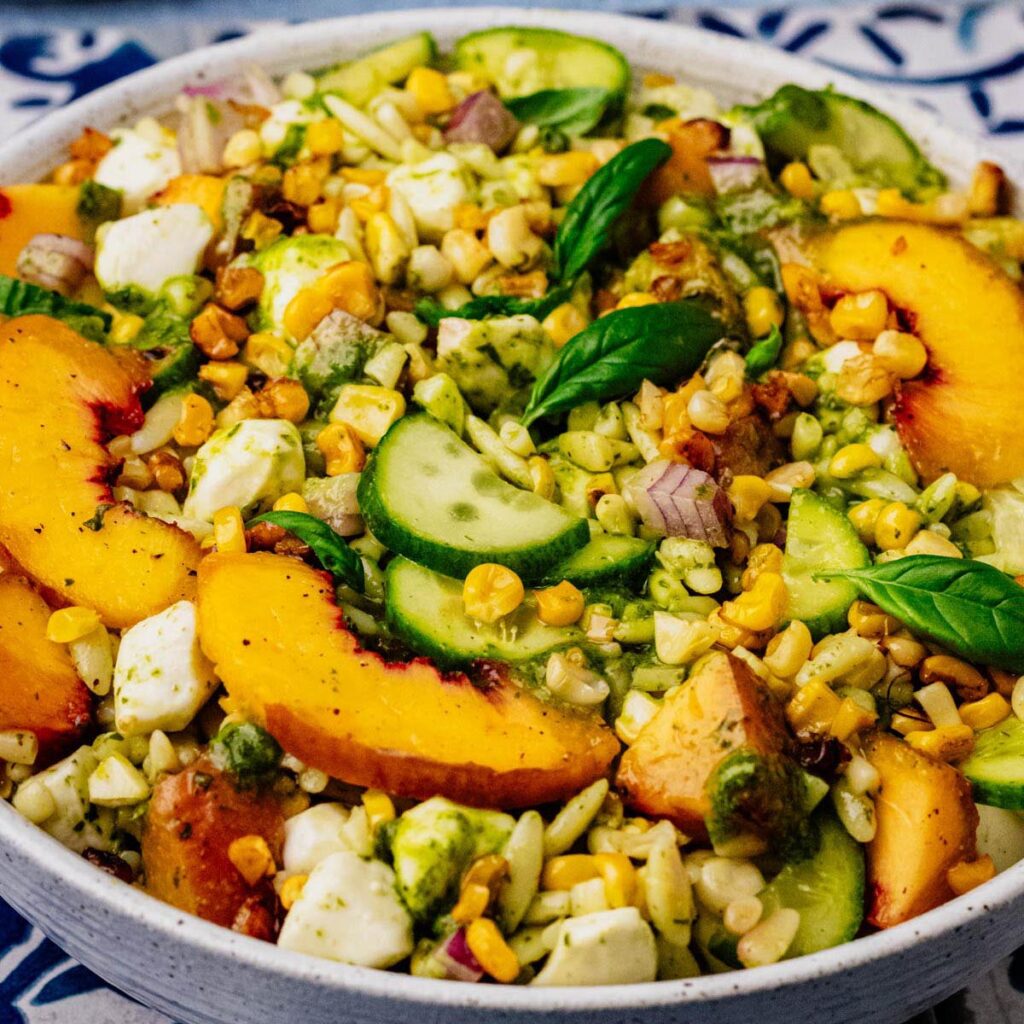 Summer orzo salad with grilled peaches, corn, cucumber, mozzarella, and basil vinaigrette.