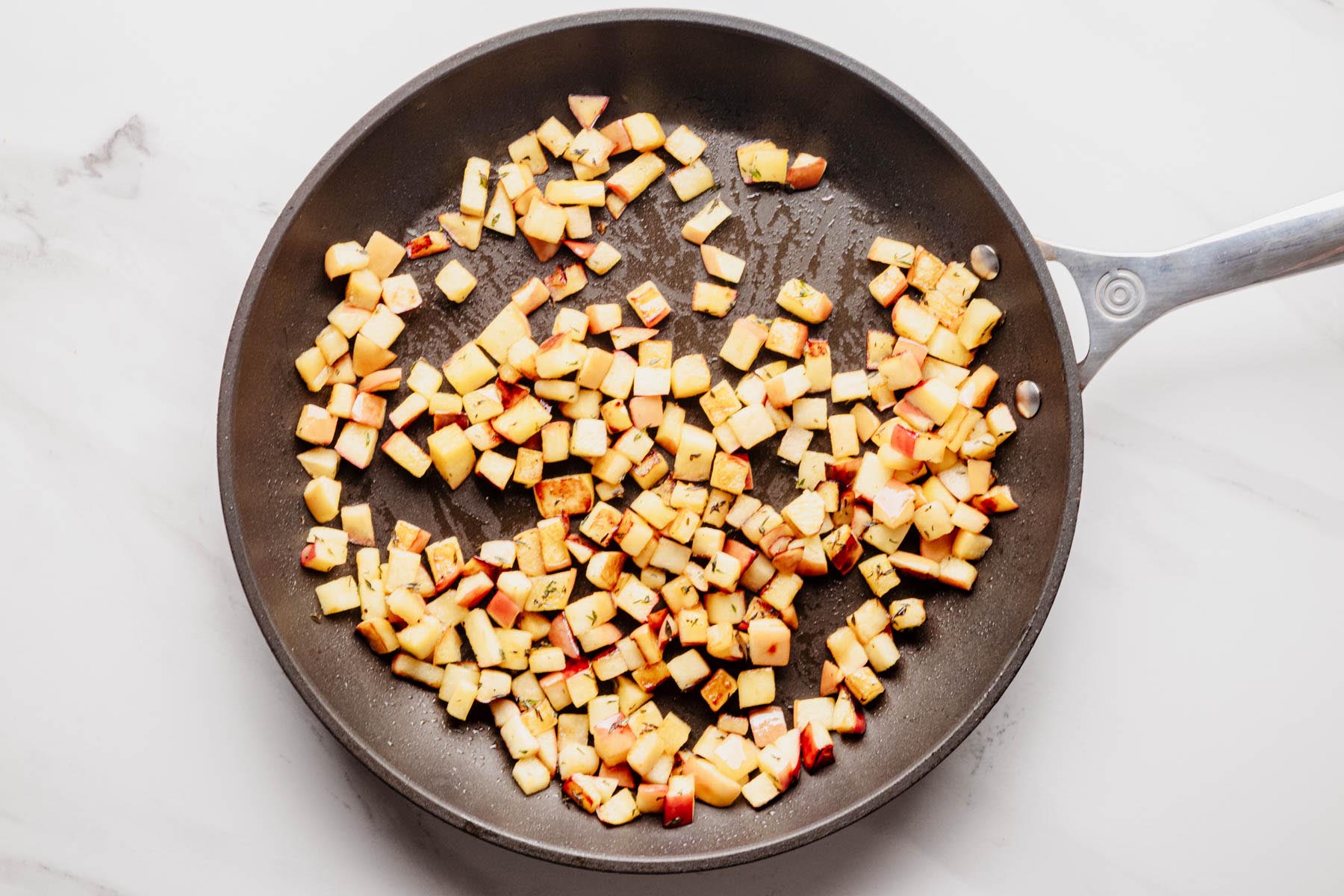Diced apples saut&eacute;ed with fresh thyme in a skillet until tender and lightly golden.
