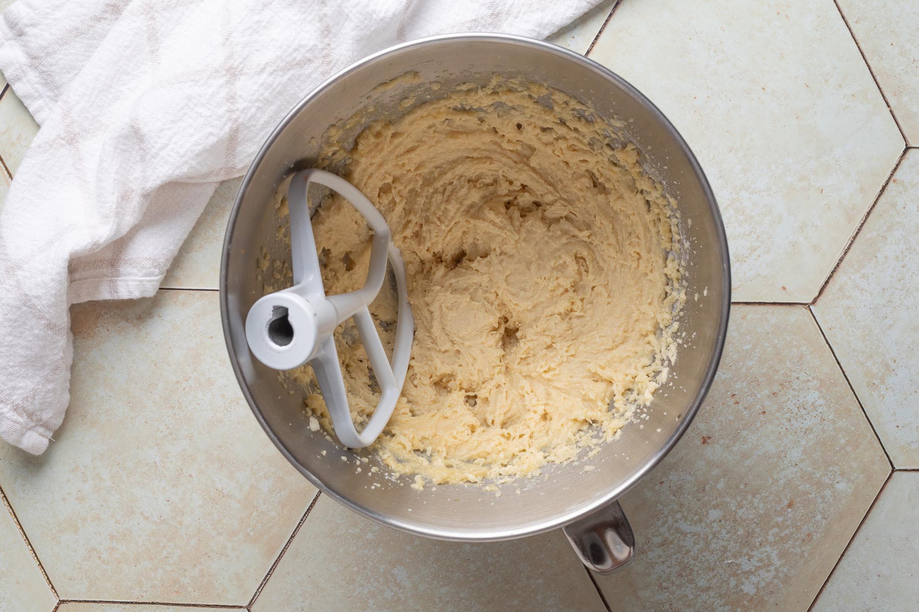 Smooth and fluffy almond cream mixture after eggs and flour have been fully incorporated, shown in a stand mixer bowl with a paddle attachment.