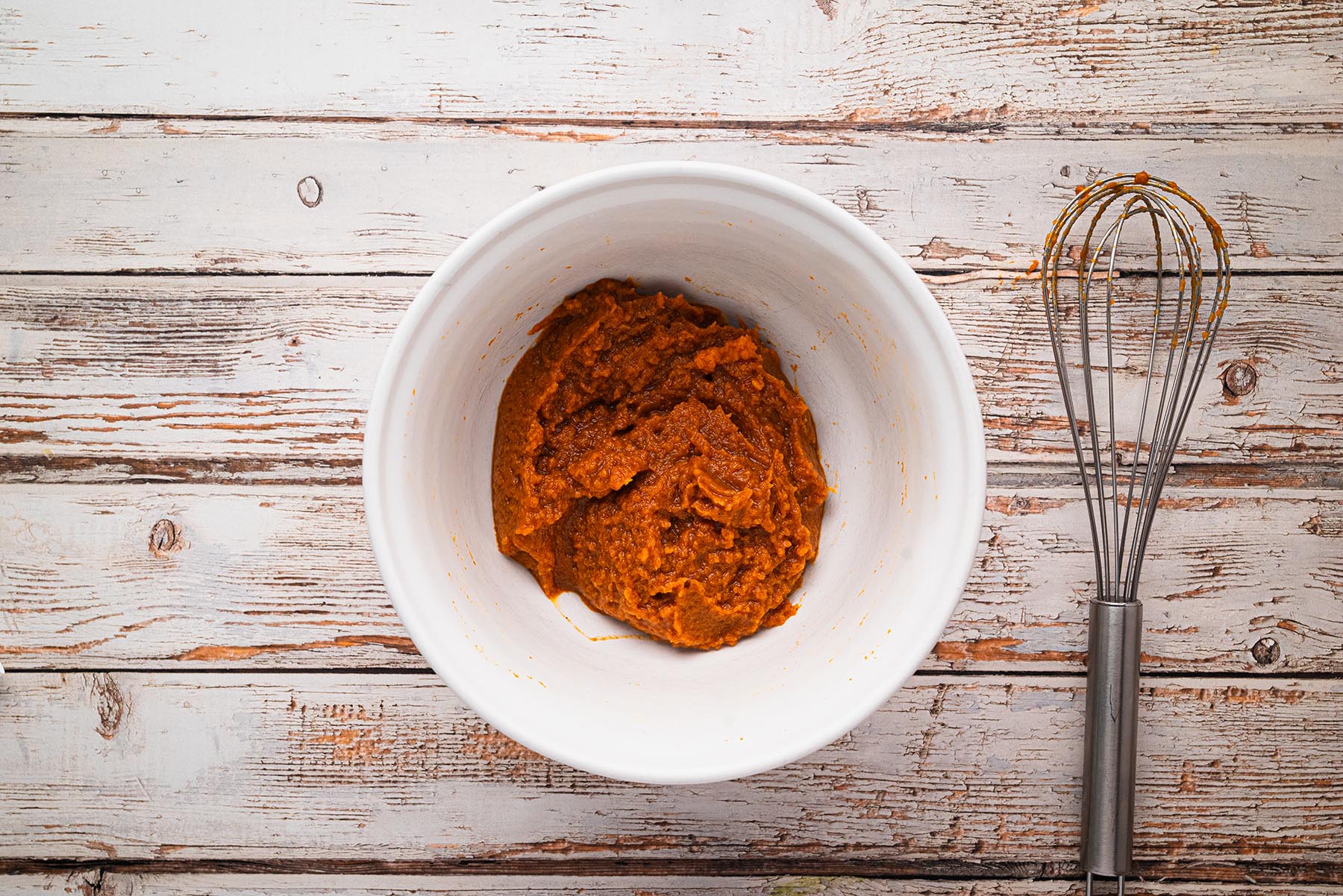 Pumpkin purée, brown sugar, maple syrup, and spices whisked together in a glass bowl until smooth.