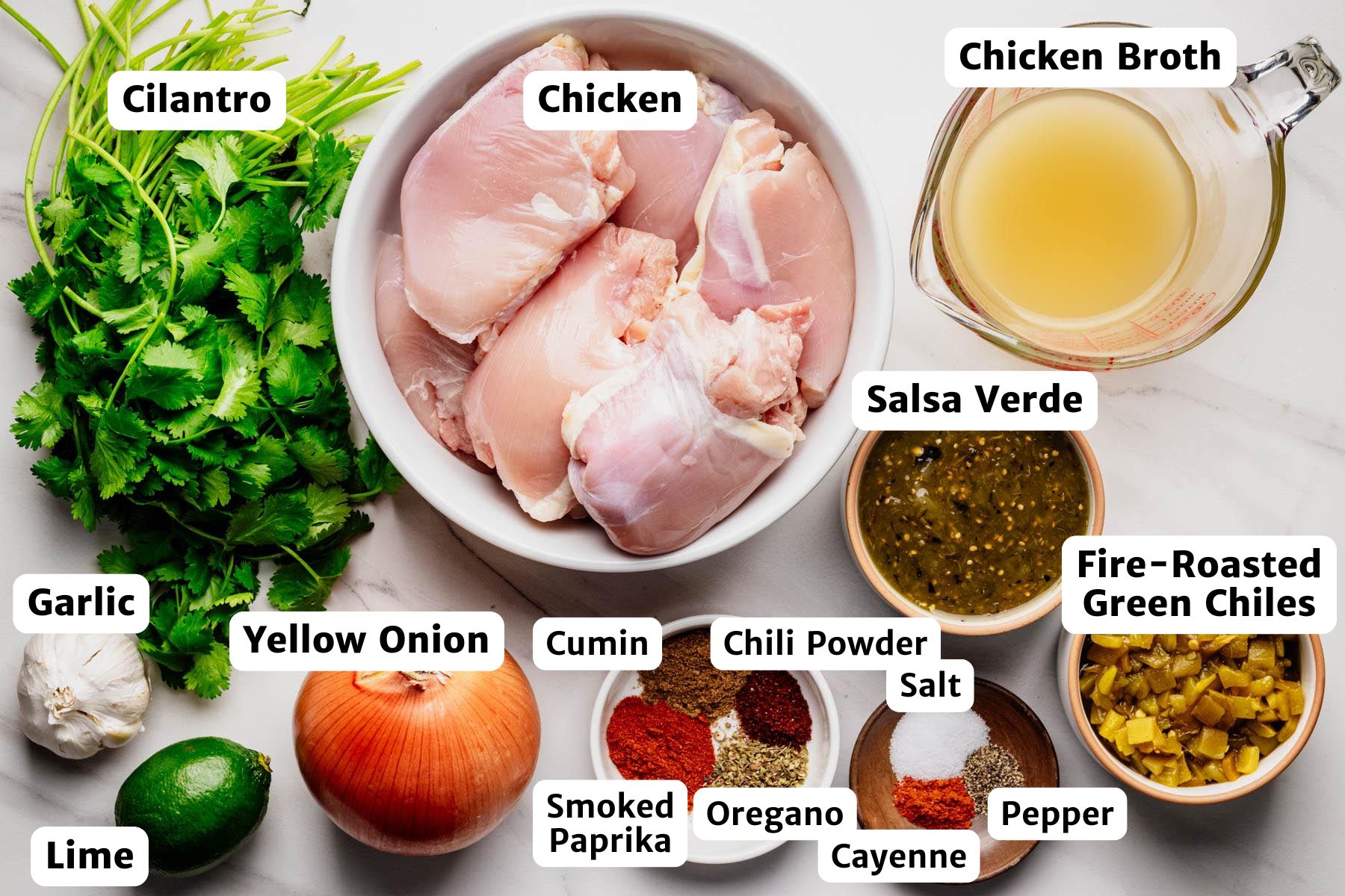 Labeled ingredient photo showing cilantro, chicken, chicken broth, salsa verde, fire-roasted green chiles, pepper, cayenne, oregano, smoked paprika, cumin, chili powder, salt, yellow onion, garlic, and lime.
