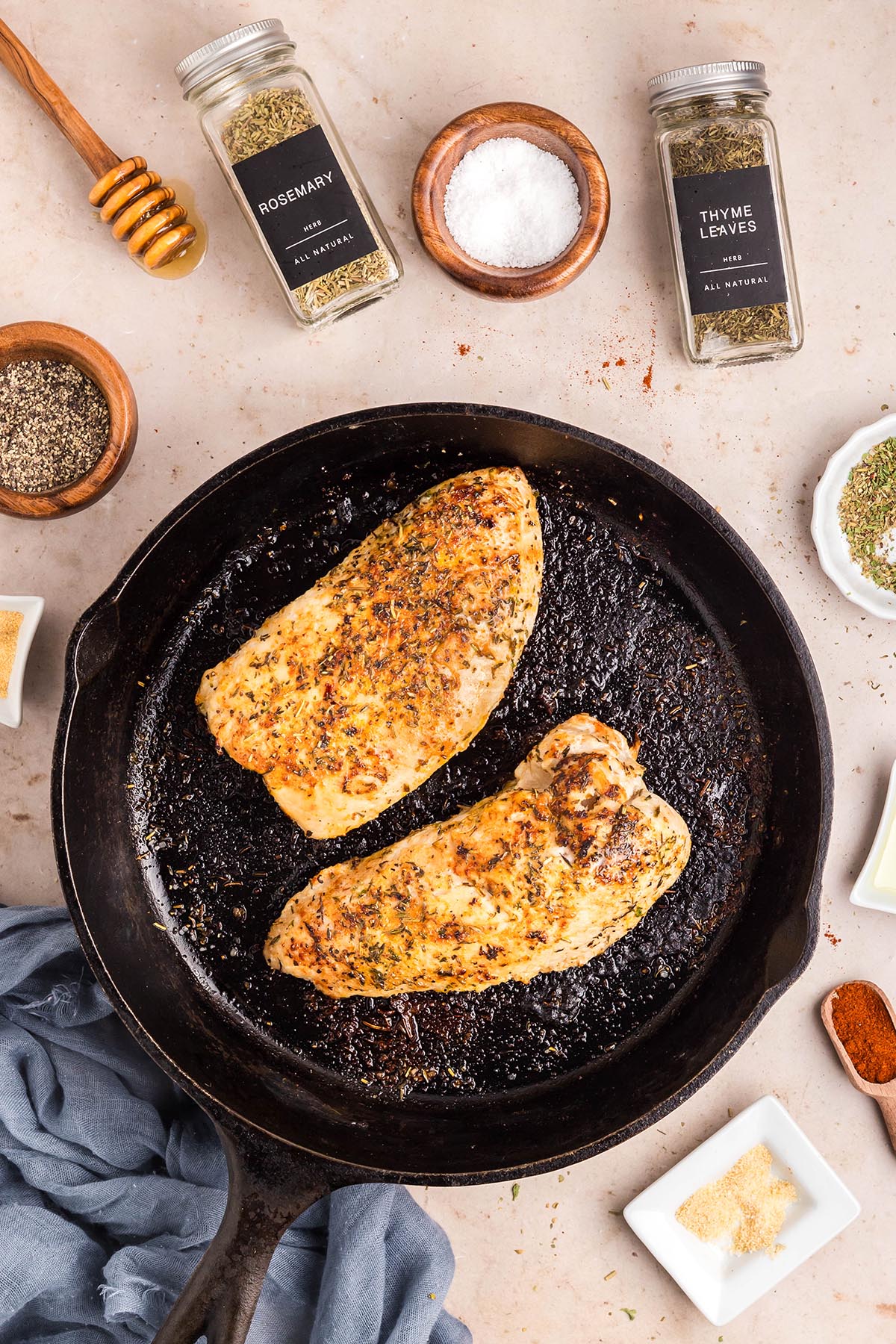 Seared herb-crusted turkey breast tenderloins in a cast-iron skillet, ready to go into the oven.