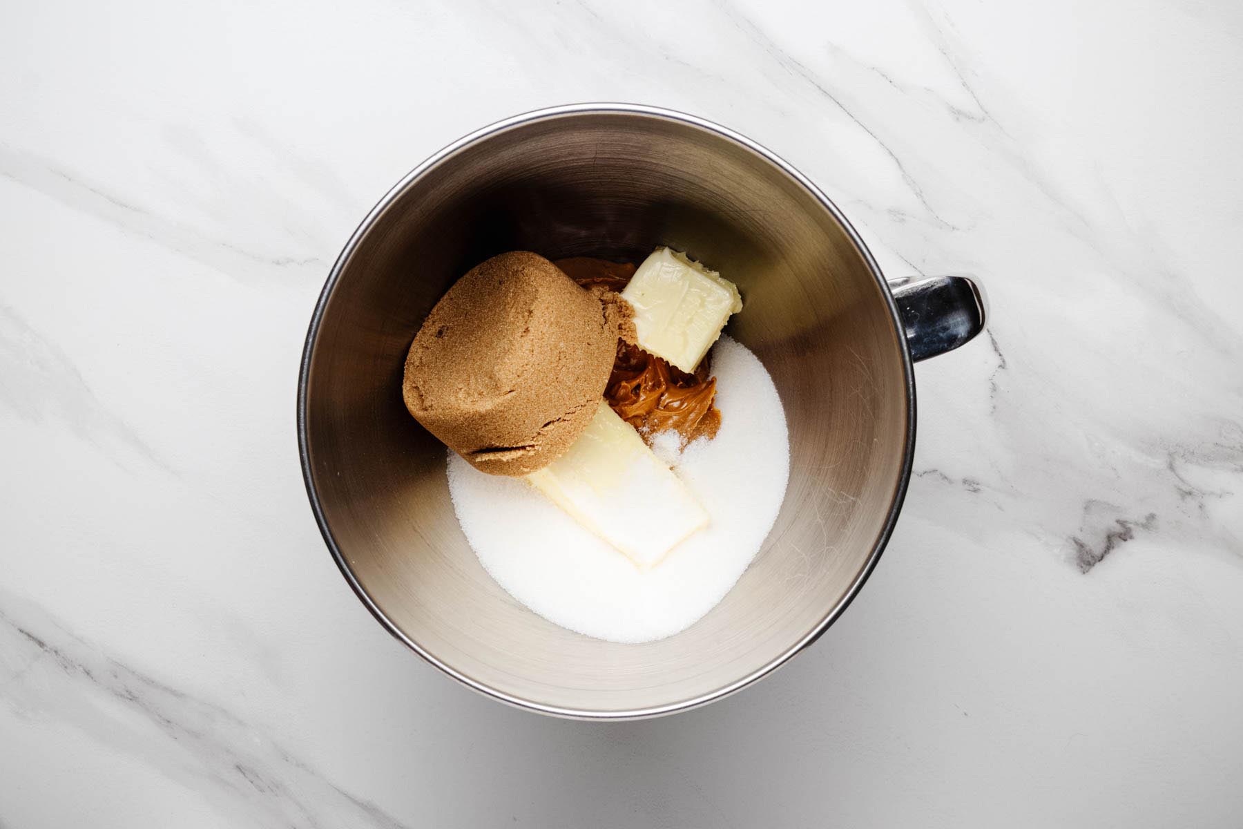 Softened butter, creamy peanut butter, brown sugar, and granulated sugar in a stand mixer bowl before creaming.