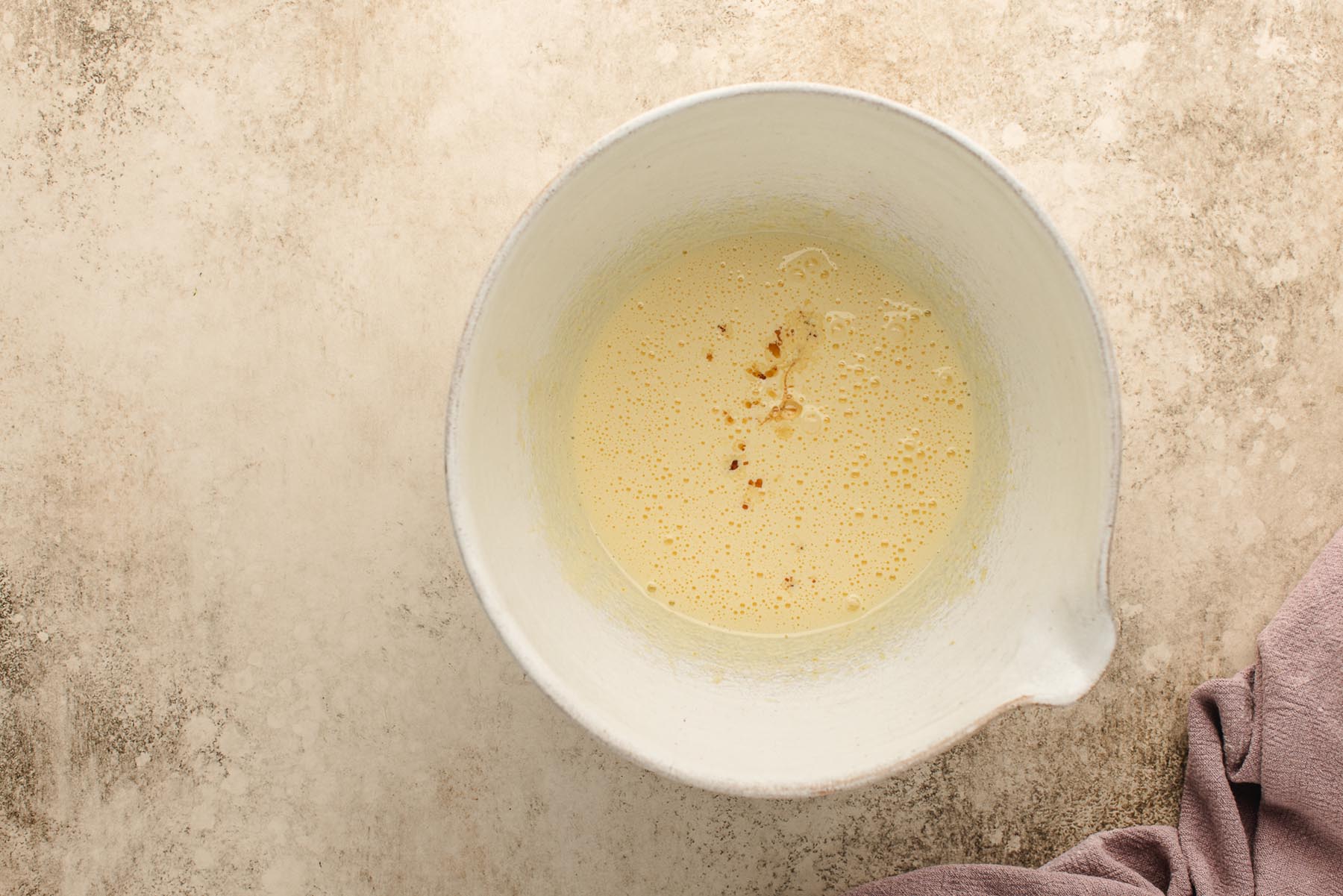 Whipped mixture with vanilla added in the center, ready to mix.