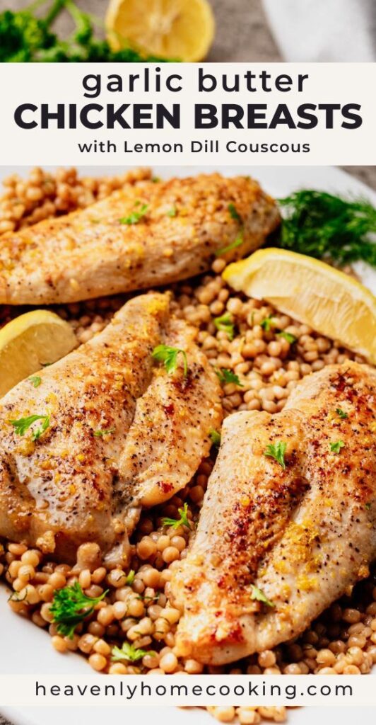 Seared garlic butter chicken breasts served over lemon dill couscous on a white platter, garnished with fresh herbs and lemon wedges.