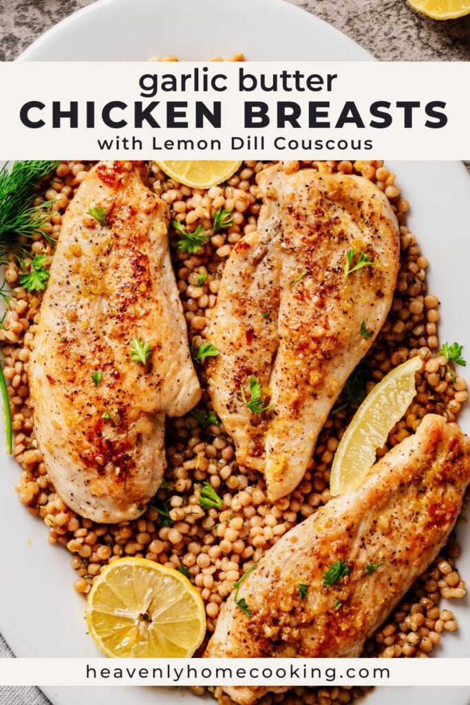 Overhead view of garlic butter chicken breasts served on a bed of lemon dill couscous, garnished with fresh herbs and lemon slices on a white platter.