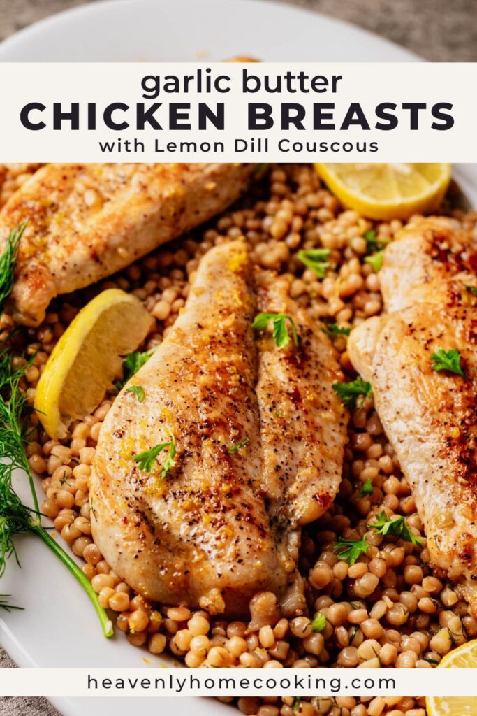 Overhead view of garlic butter chicken breasts on a bed of lemon dill couscous, topped with fresh herbs and surrounded by lemon wedges on a white platter.