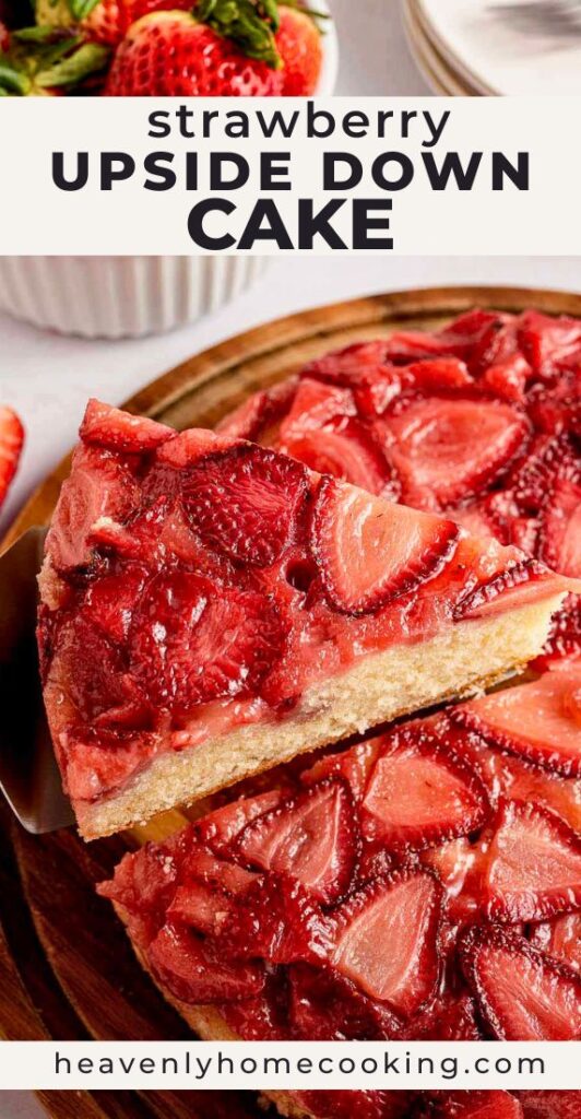 Alt text: Slice of strawberry upside down cake on a wooden board, topped with glossy baked strawberries, with a bowl of fresh strawberries and stacked white plates in the background.