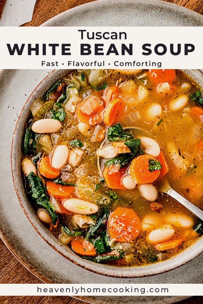 Overhead view of a bowl of Tuscan white bean soup filled with carrots, celery, spinach, and cannellini beans in a golden broth, served in a rustic stoneware bowl.