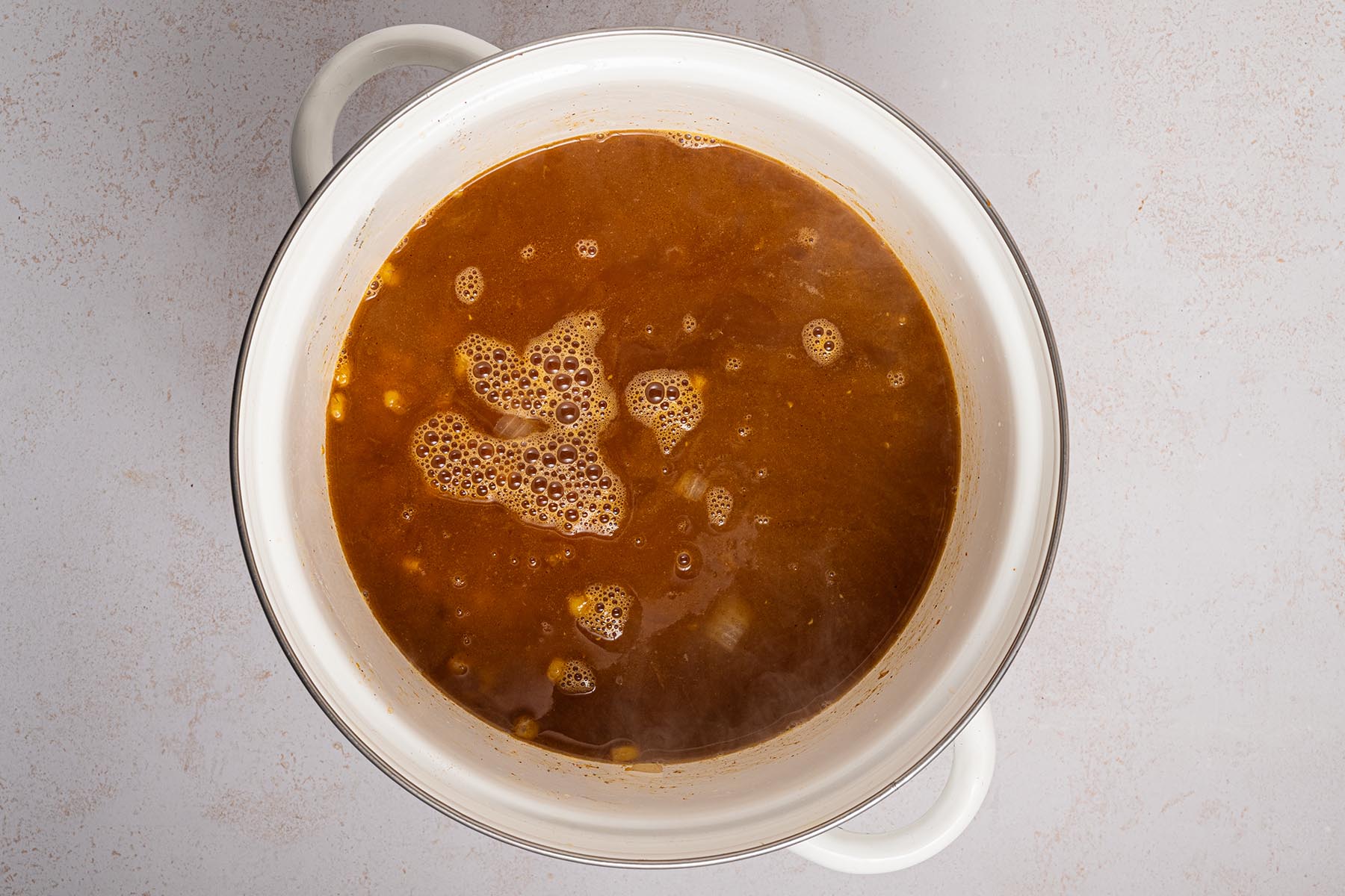 Pot of corn and spices simmering in vegetable broth for Mexican street corn chowder.