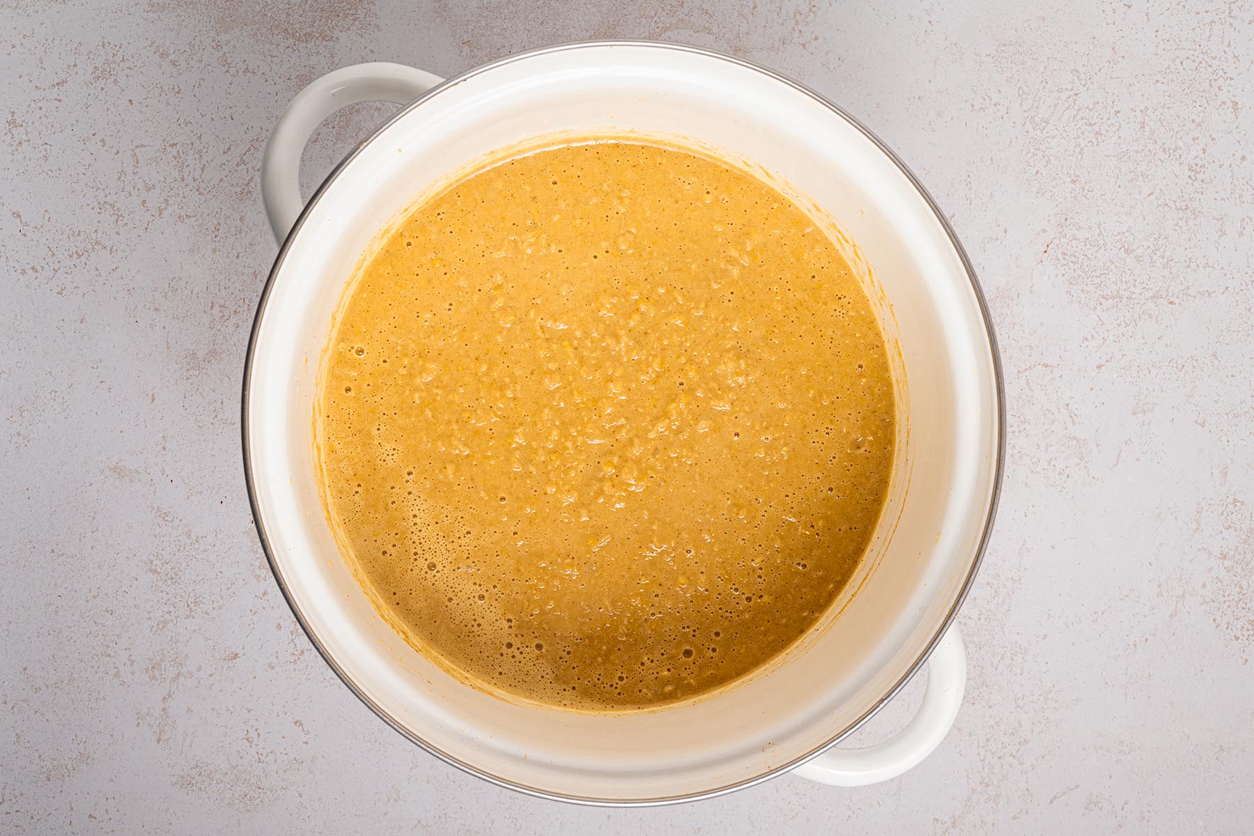 Large white pot filled with blended Mexican street corn chowder, showing a smooth, creamy texture.