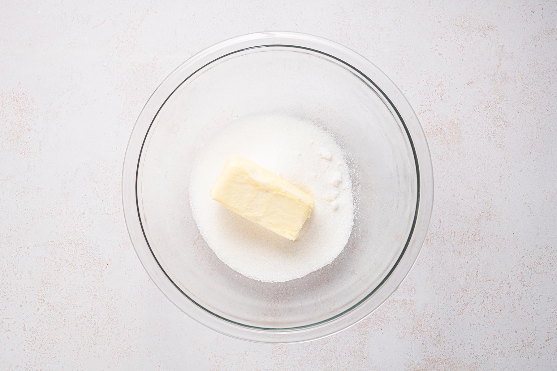 Butter and sugar in a mixing bowl before creaming.
