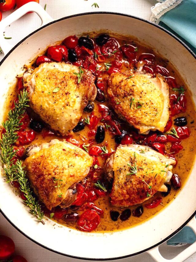 Chicken Proven&ccedil;al with crispy chicken thighs, cherry tomatoes, olives, and herbs simmered in a skillet.