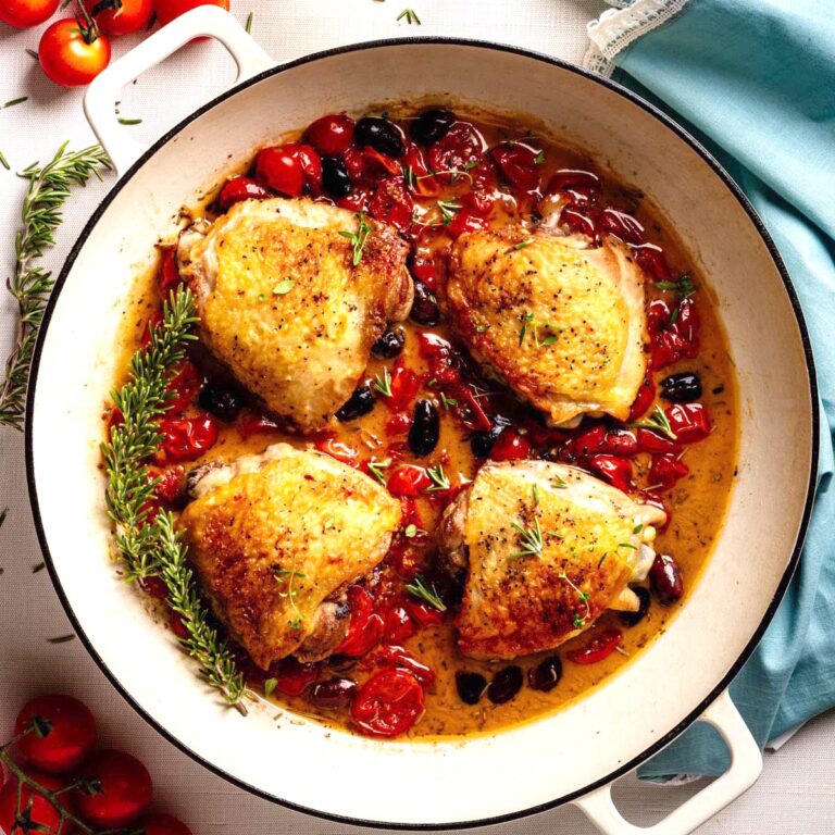 Chicken Proven&ccedil;al with crispy chicken thighs, cherry tomatoes, olives, and herbs simmered in a skillet.