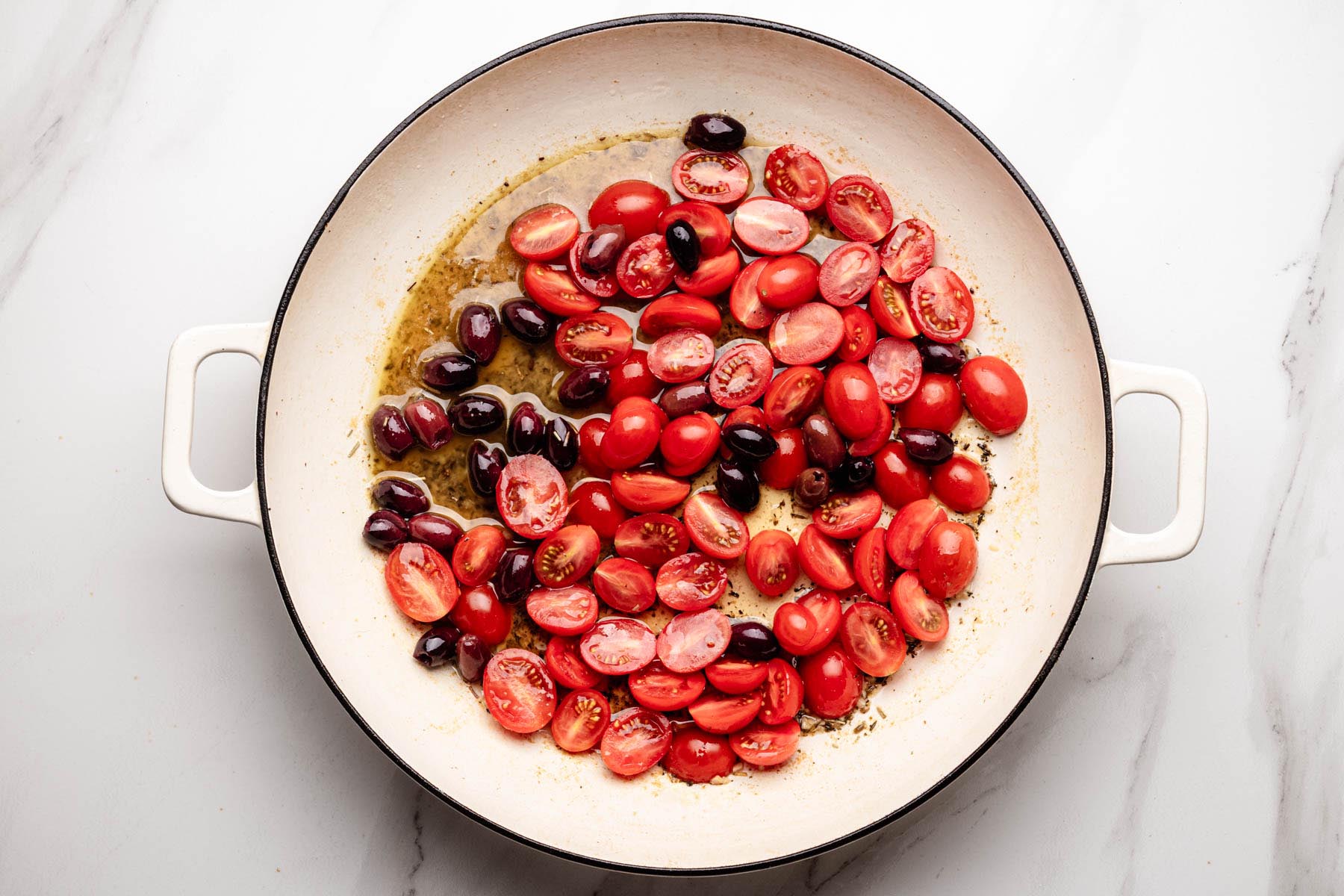 Cherry tomatoes and olives added to the skillet for Proven&ccedil;al chicken sauce.