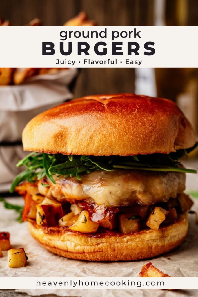 Juicy ground pork burger topped with melted cheese and greens on a toasted bun with roasted potatoes. Vertical Pinterest pin for an easy pork burger dinner recipe from Heavenly Home Cooking.