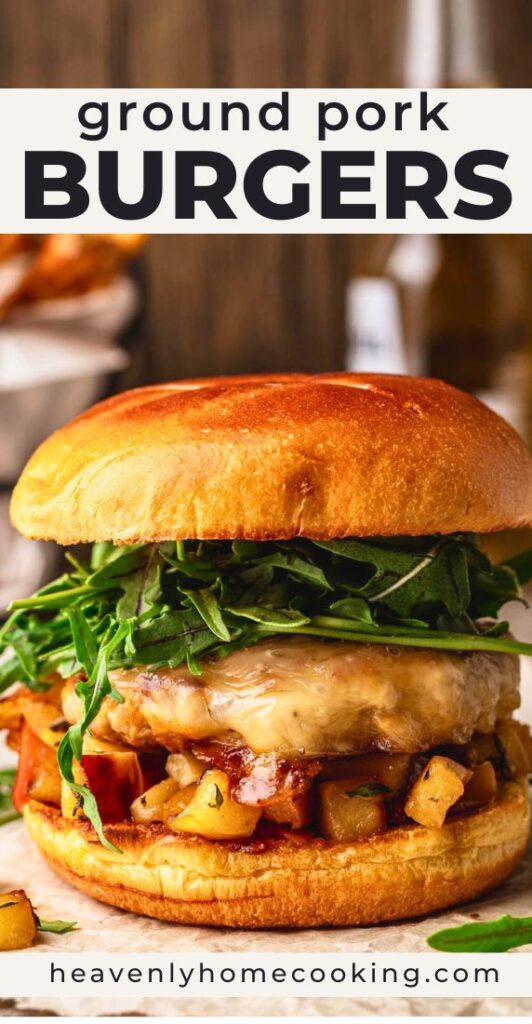 Juicy ground pork burger topped with melted cheese, greens, and caramelized onions on a toasted bun. Vertical Pinterest pin for an easy pork burger recipe from Heavenly Home Cooking.