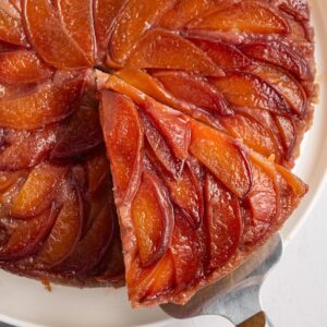 Close-up of upside down cake with peaches arranged in a glossy caramelized spiral pattern.