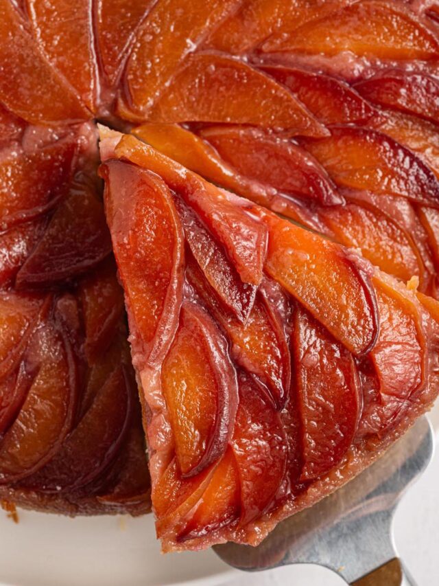 Close-up of upside down cake with peaches arranged in a glossy caramelized spiral pattern.
