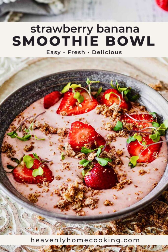 Strawberry banana smoothie bowl topped with sliced strawberries, crunchy topping, and microgreens in a dark bowl. Vertical Pinterest pin for an easy and refreshing smoothie bowl breakfast recipe from Heavenly Home Cooking.