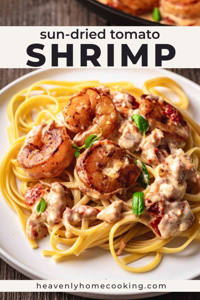 Creamy sun-dried tomato shrimp served over pasta with garlic cream sauce and fresh basil. Vertical Pinterest pin for an easy shrimp pasta dinner recipe from Heavenly Home Cooking.