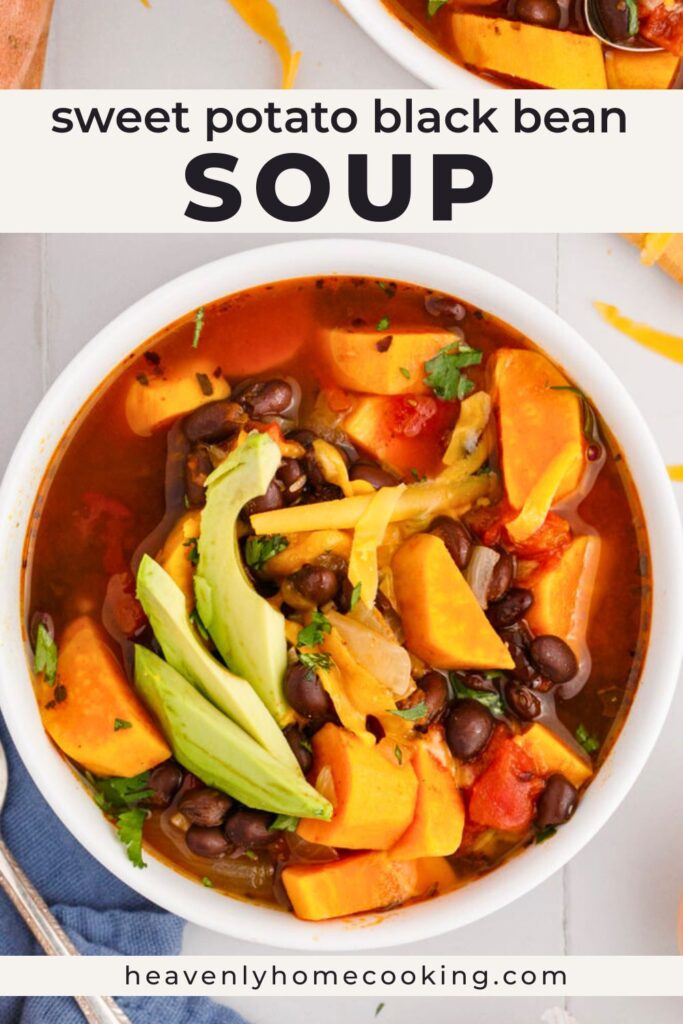 Sweet potato black bean soup with chunks of sweet potato, black beans, tomatoes, avocado slices, and shredded cheese in a white bowl. Vertical Pinterest pin for a hearty sweet potato black bean soup recipe from Heavenly Home Cooking.