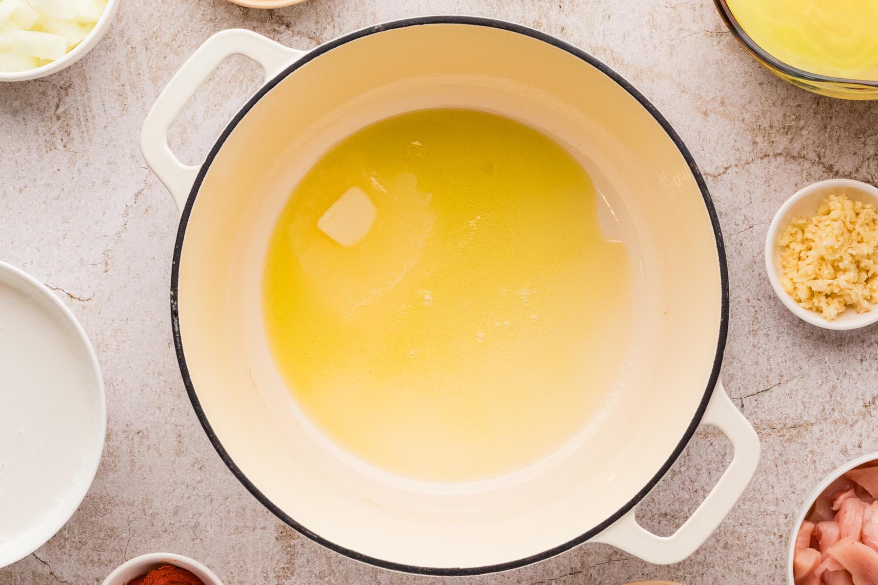 Butter and olive oil melting in a Dutch oven for Thai chicken soup base.
