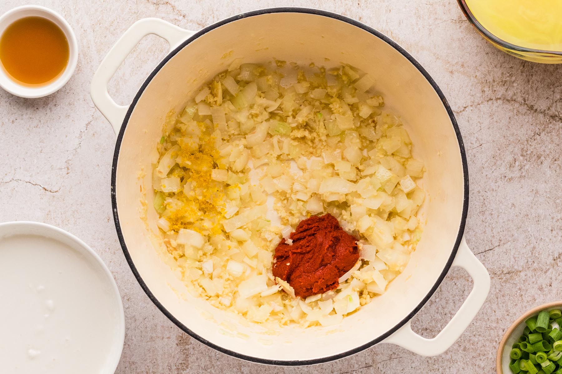 Red curry paste and lemon zest added to aromatics for Thai chicken curry soup.