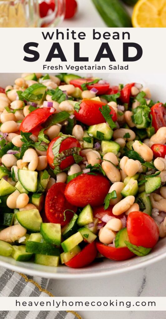 White bean salad with cannellini beans, cherry tomatoes, cucumber, red onion, and fresh herbs in a serving bowl. Vertical Pinterest pin for a fresh Mediterranean-inspired vegetarian white bean salad recipe from Heavenly Home Cooking.