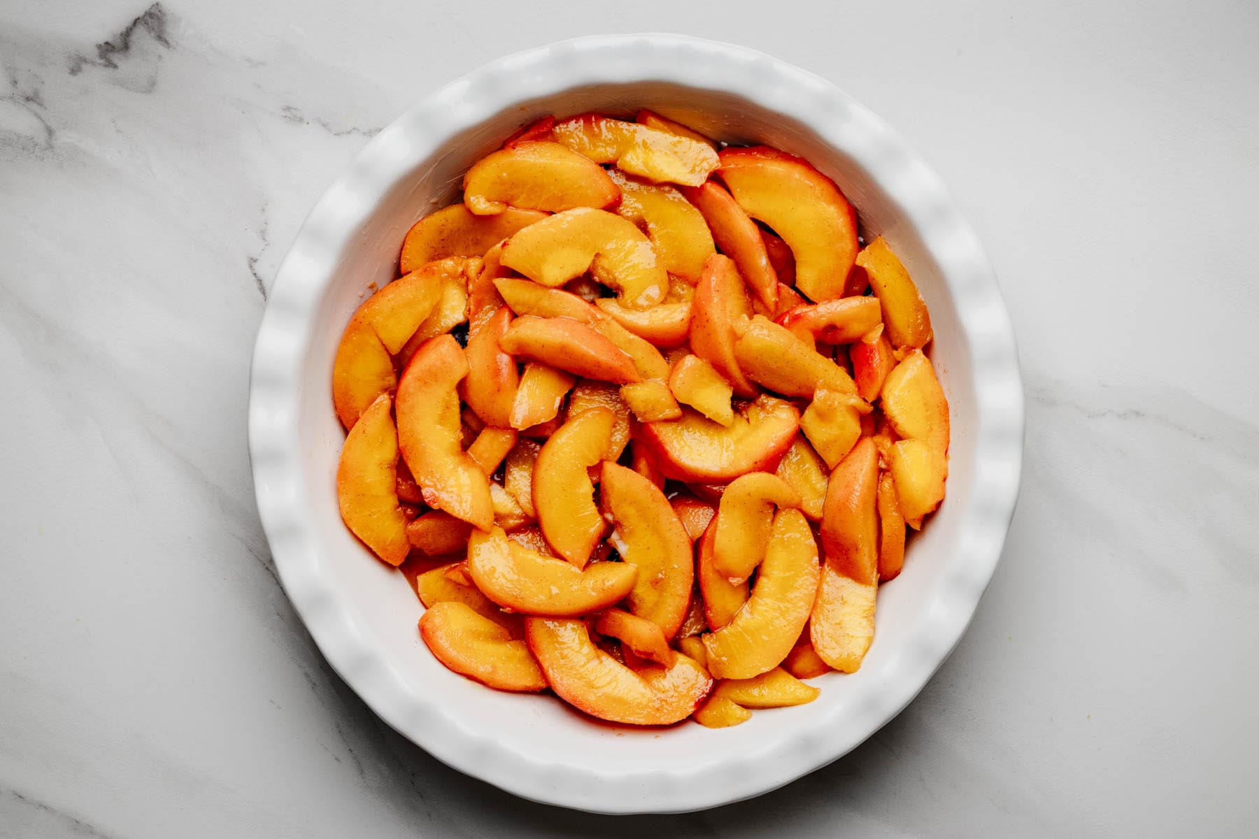 Peach filling spooned over blueberries in a deep-dish pie plate.