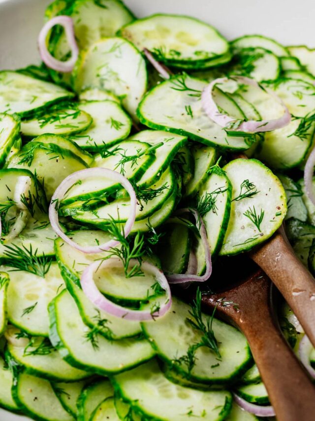 Close-up of English cucumber dill salad with fresh dill and thinly sliced shallot tossed in a light white wine vinaigrette.