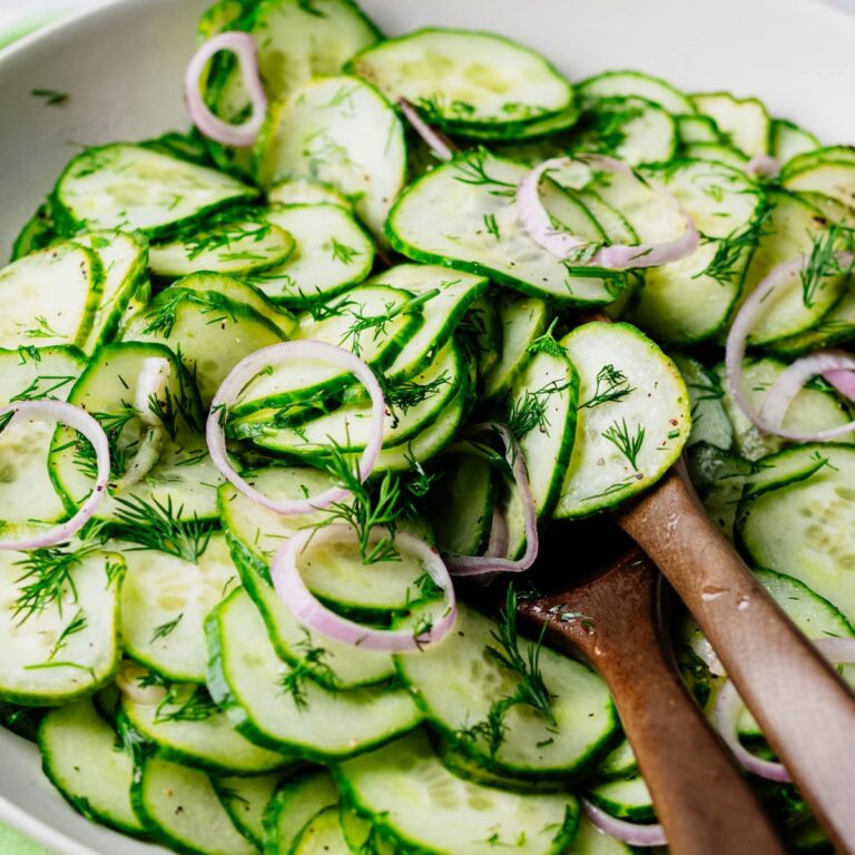 Close-up of English cucumber dill salad with fresh dill and thinly sliced shallot tossed in a light white wine vinaigrette.