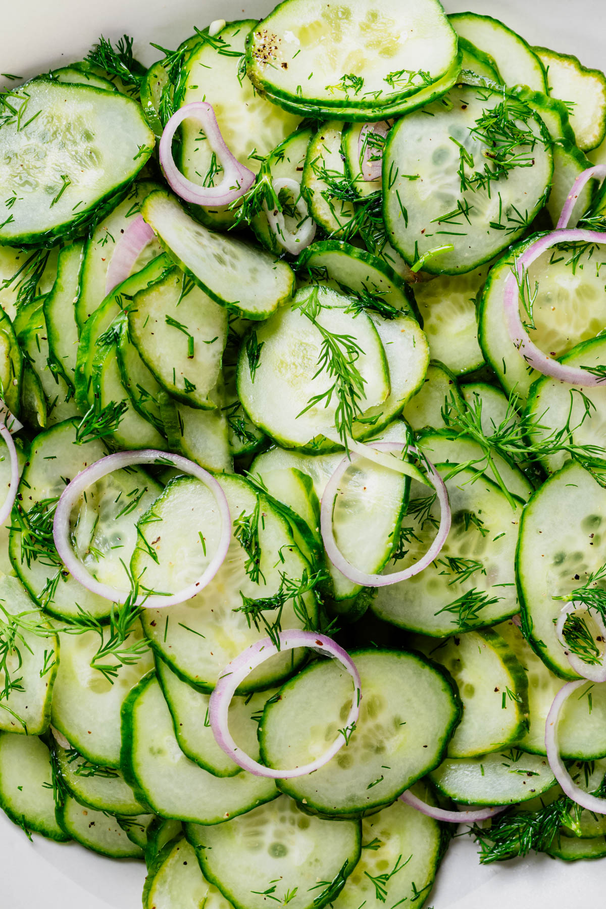 Close-up of cucumber dill salad with thinly sliced English cucumbers, fresh dill, shallot, and a light white wine vinaigrette.