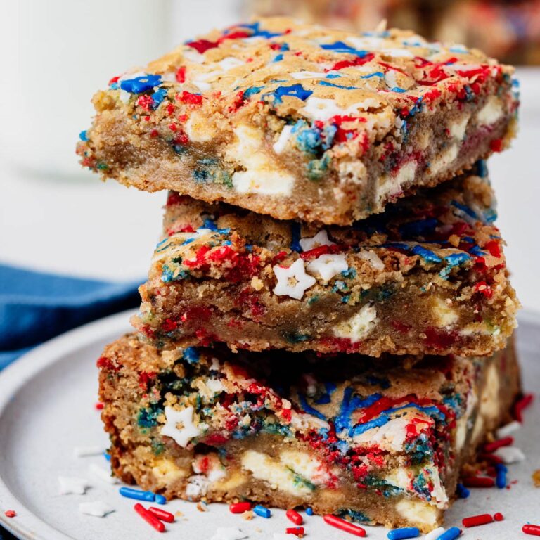 Stack of chewy fireworks blondies made with browned butter, white chocolate chunks, and red, white, and blue sprinkles.