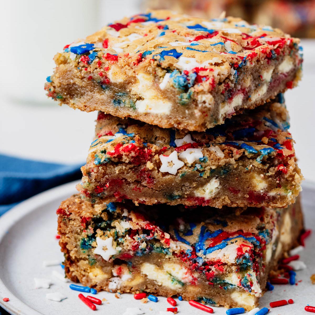Stack of chewy fireworks blondies made with browned butter, white chocolate chunks, and red, white, and blue sprinkles.