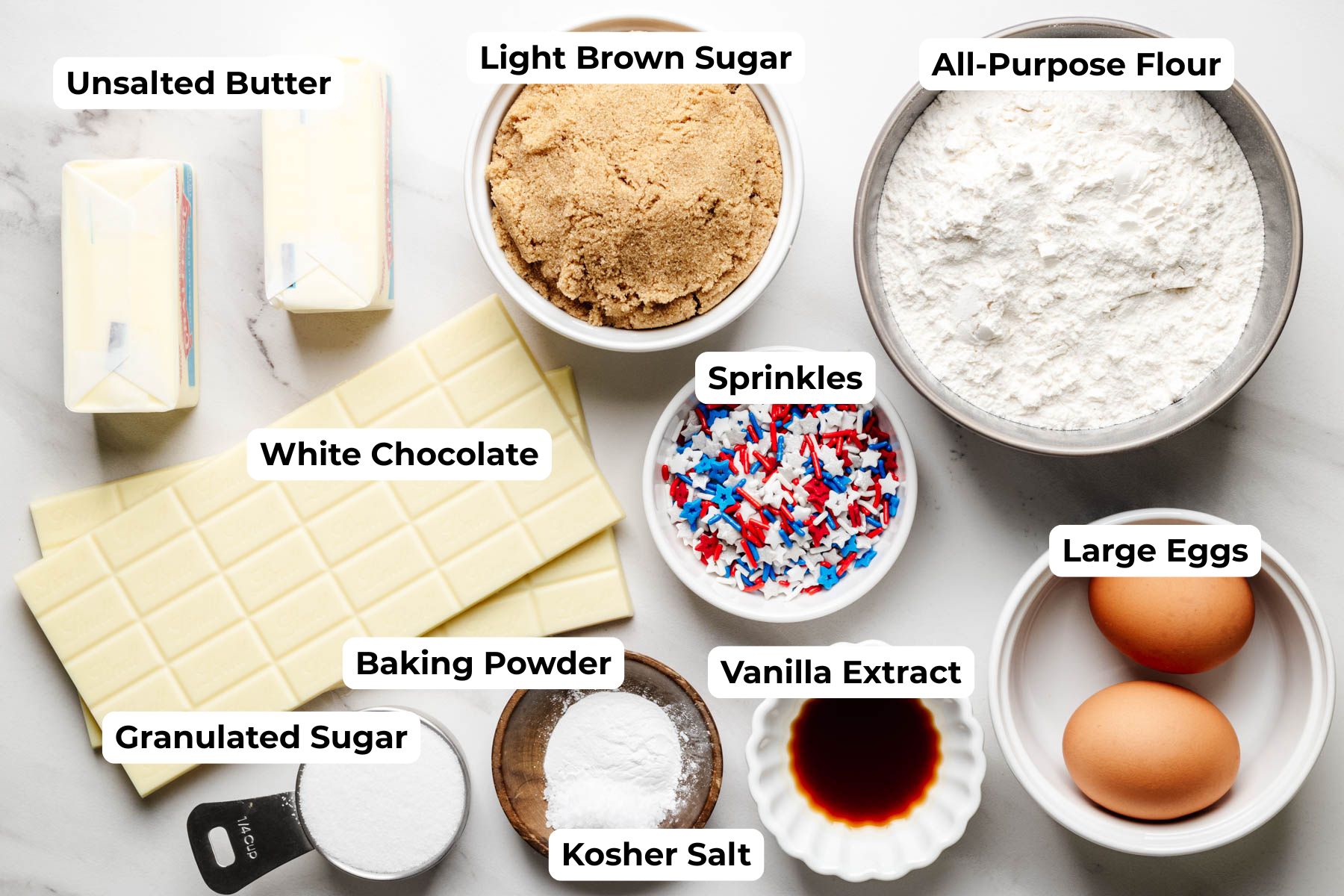 Ingredients for Fireworks Blondies including brown sugar, flour, white chocolate, butter, eggs, vanilla extract, baking powder, salt, and patriotic sprinkles.