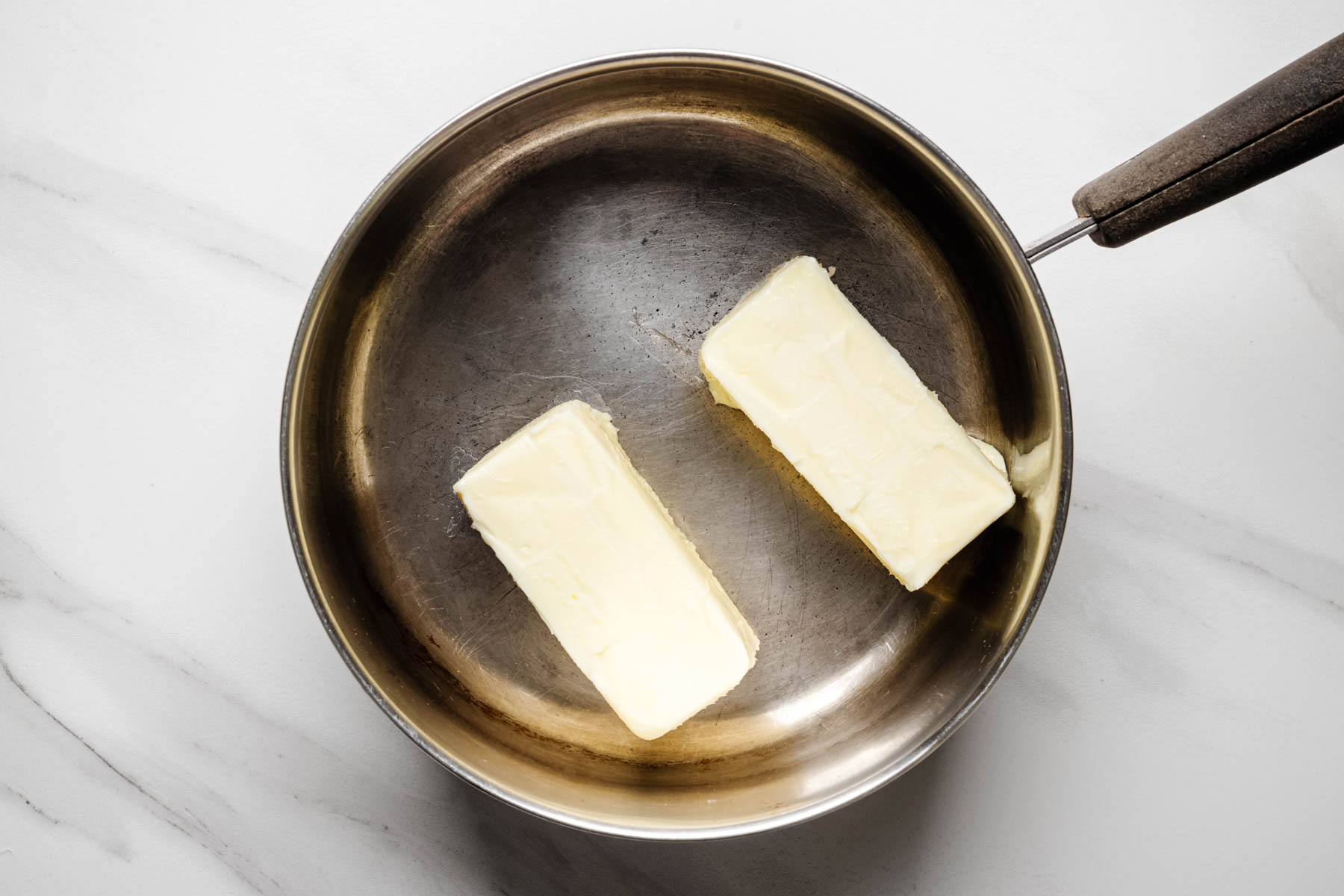 Unsalted butter melting in a saucepan before being browned for fireworks blondies.