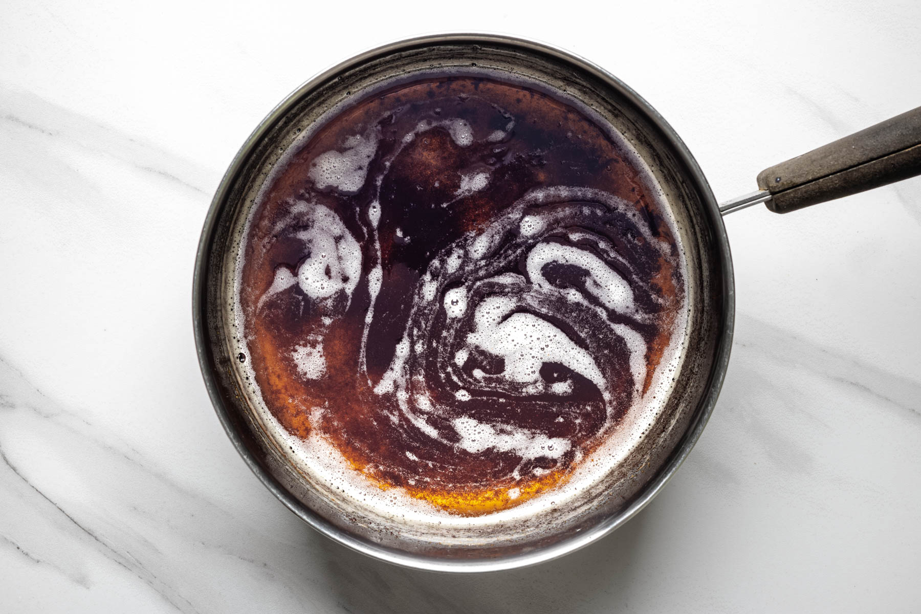 Brown butter in a saucepan with golden brown milk solids and a deep amber color.