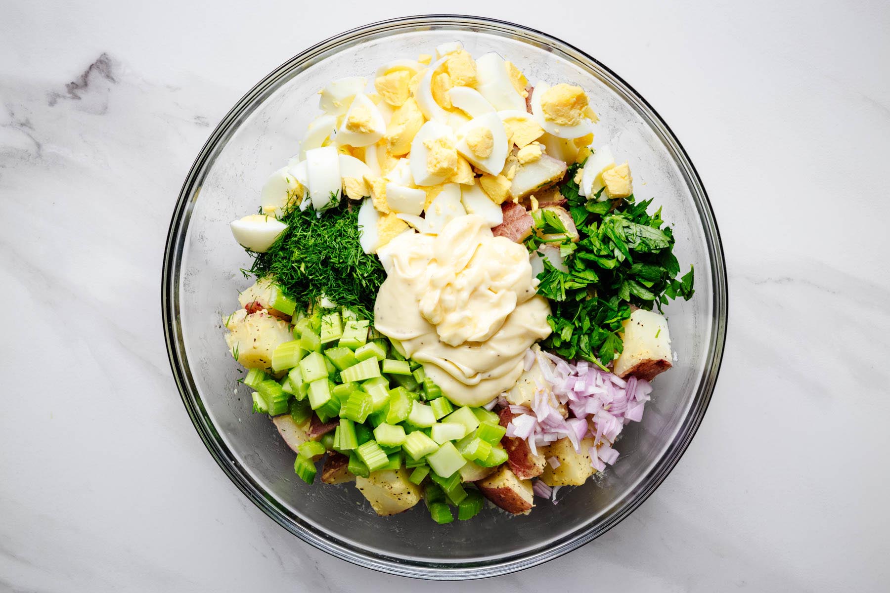 Potatoes with celery, herbs, eggs, shallot, and dressing added