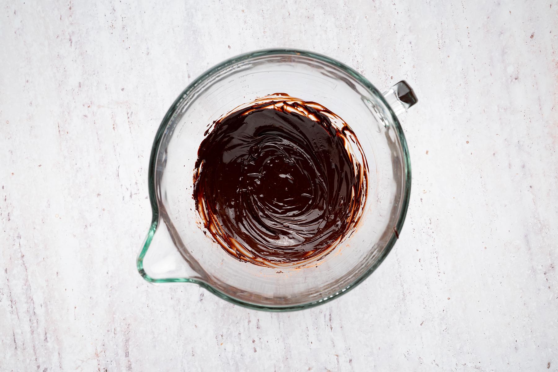 Butter and cocoa powder whisked together into a smooth, glossy chocolate mixture.
