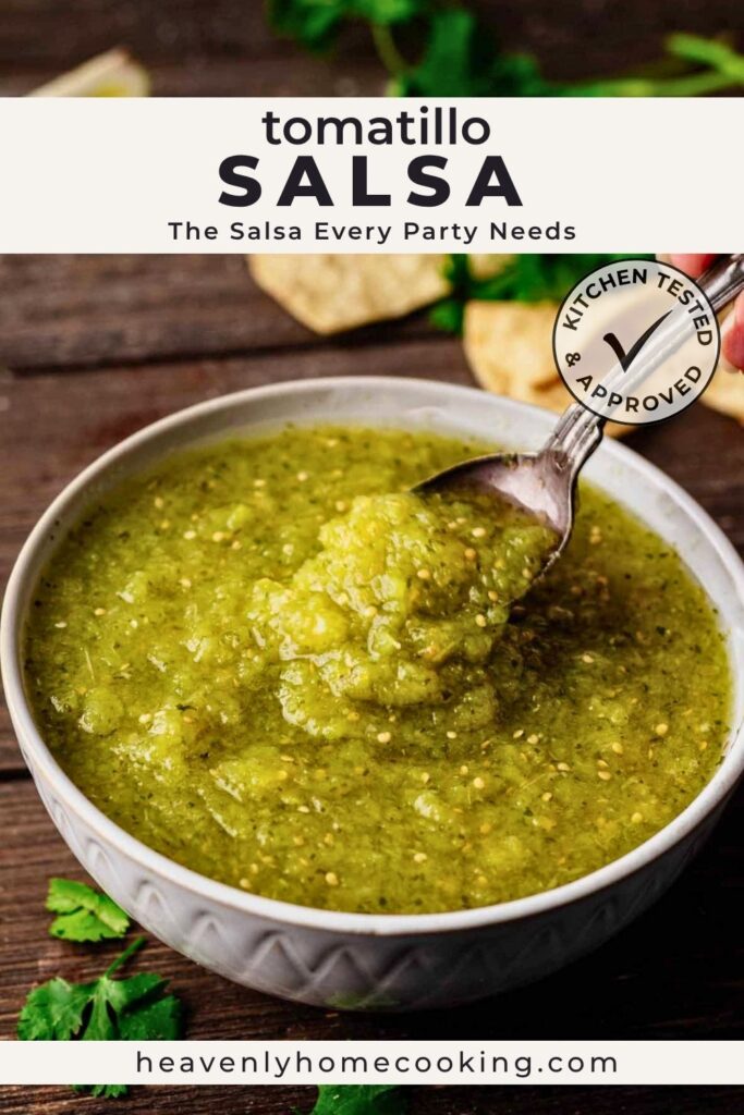 Bowl of homemade tomatillo salsa verde with a spoon lifting a scoop of chunky salsa, surrounded by tortilla chips and fresh cilantro. Vertical Pinterest pin for a tomatillo salsa recipe from Heavenly Home Cooking.