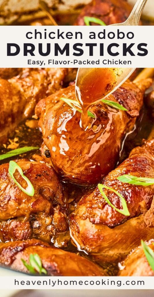 A spoon drizzles glossy adobo sauce over golden-brown chicken drumsticks simmered in a rich savory sauce and garnished with sliced green onions. This vertical Pinterest pin features a homemade chicken adobo drumsticks recipe from Heavenly Home Cooking.