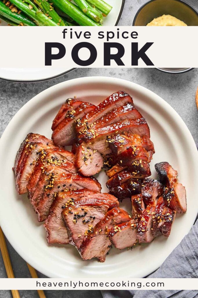 An overhead view shows sliced and cubed five spice pork arranged on a serving platter and sprinkled with black and white sesame seeds, with sautéed bok choy and a small bowl of sauce in the background. The Pinterest pin includes the text "Five Spice Pork." This vertical Pinterest pin features a homemade five spice pork recipe from Heavenly Home Cooking.