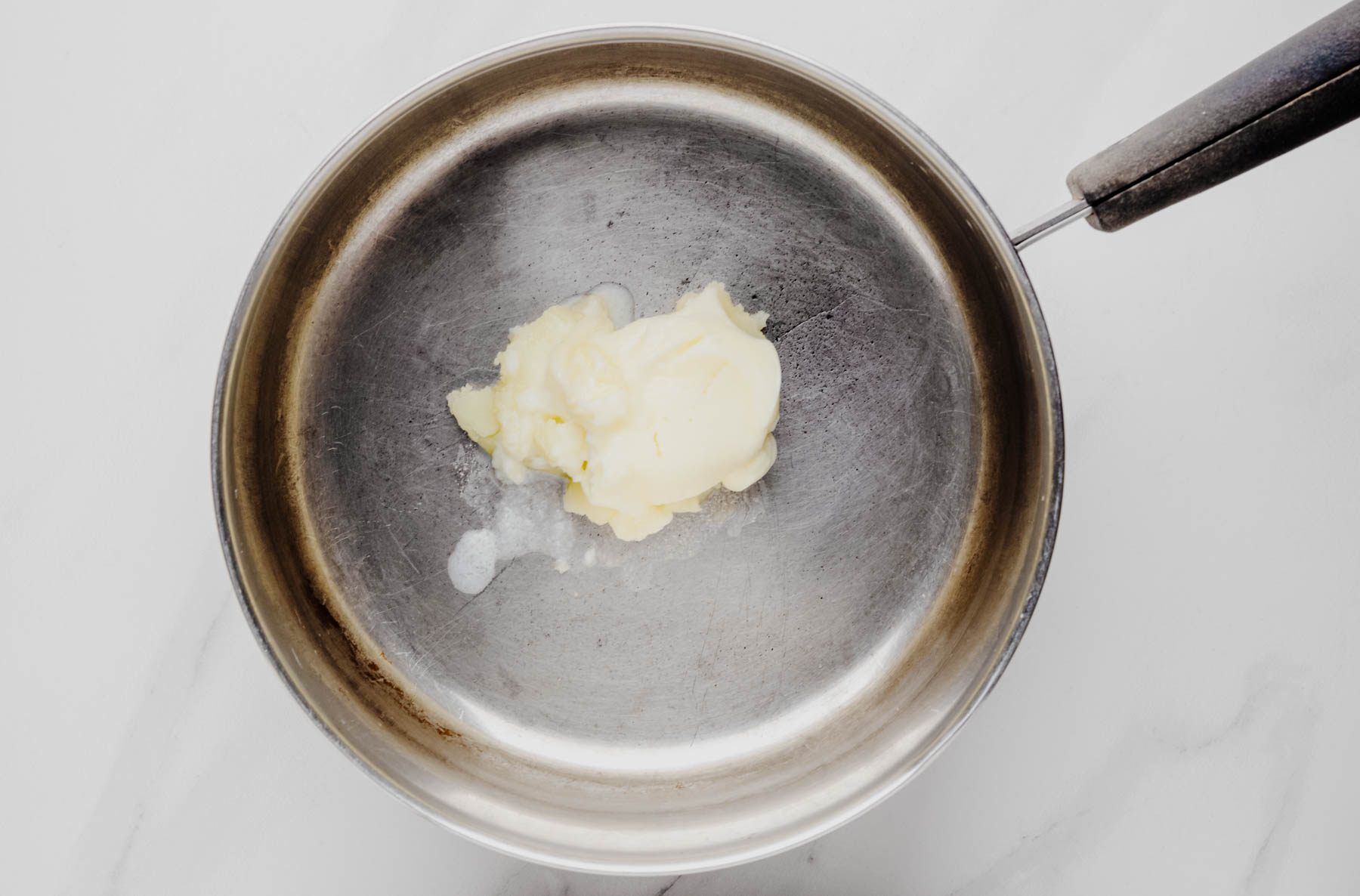 Butter melting in a small saucepan for the garlic butter topping.