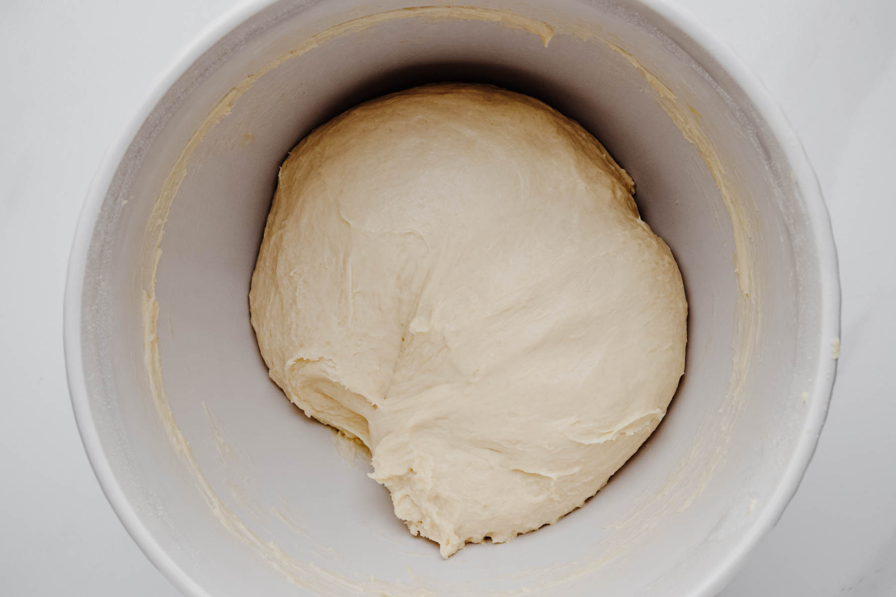 Smooth, elastic garlic dinner roll dough after kneading in a mixing bowl.